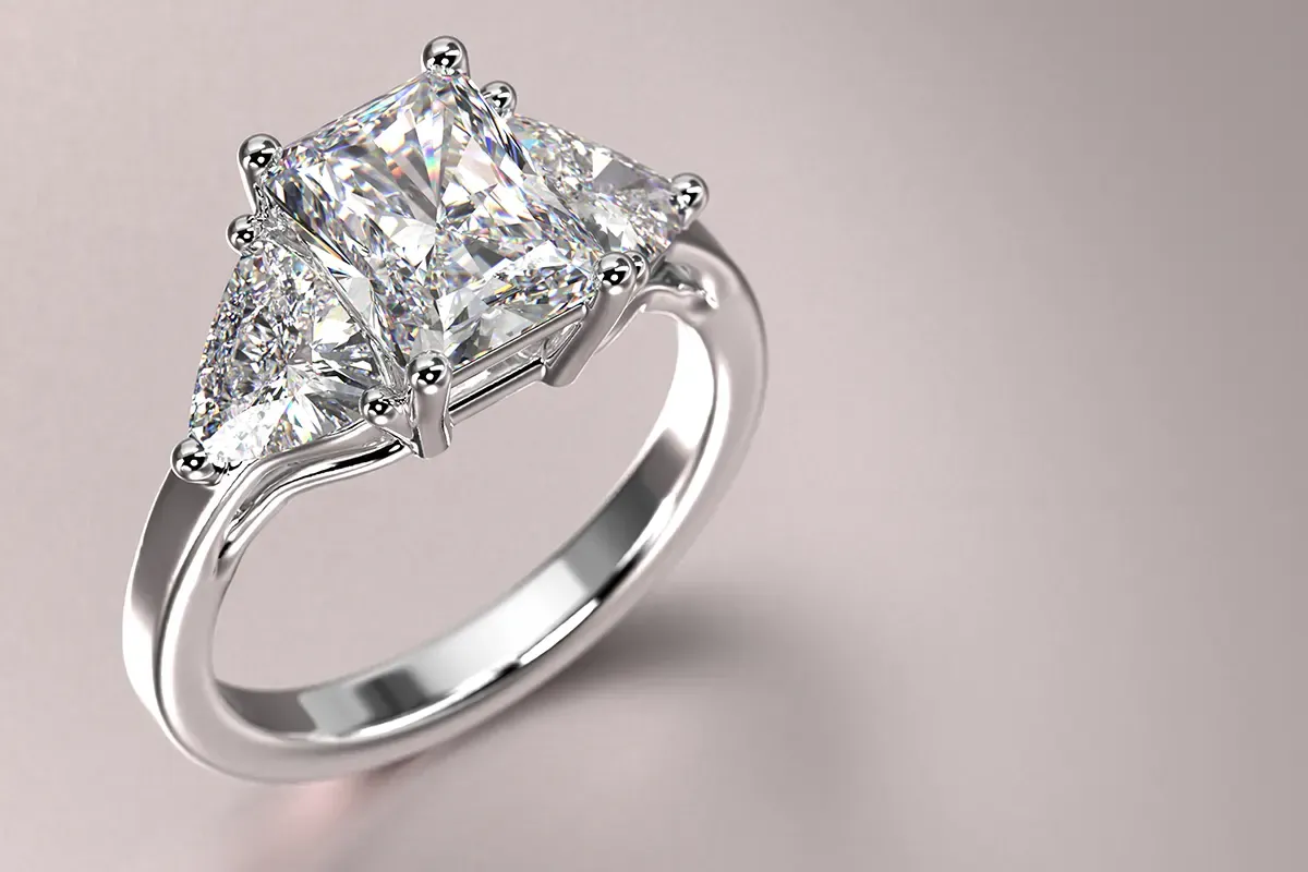 Diamond engagement ring with a radiant cut center diamond and trillion shape diamond side stones.